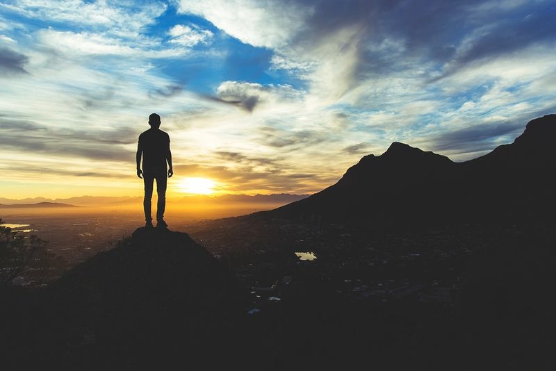 A hiker standing on a Cape Town summit at sunrise
